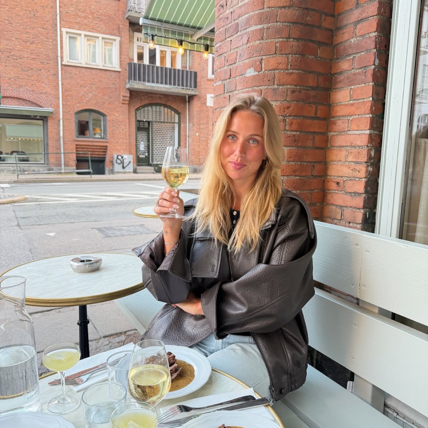 Olivia på café med et glas vin